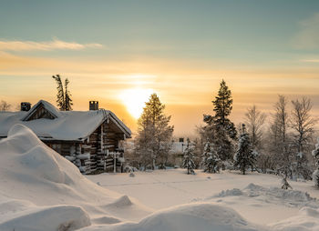 Scenic view of snow covered field against sky during sunset