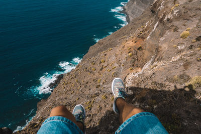 Low section of man sitting on mountain