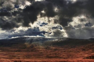 Scenic view of mountains against cloudy sky