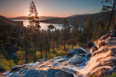 Scenic view of river amidst trees against sky during sunset