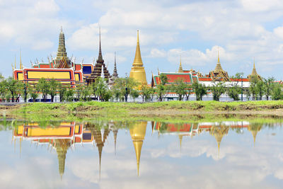 Wat phra kaew reflection in chao phraya river against sky