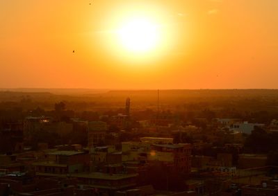 Aerial view of cityscape against clear sky during sunset