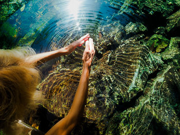 High angle view of woman gesturing at lake