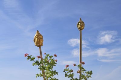 Low angle view of buddahs against sky