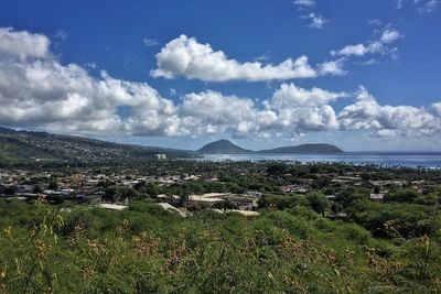 Scenic view of cityscape against cloudy sky