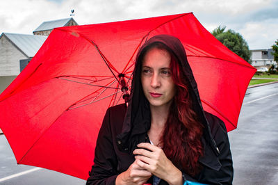 Portrait of a red haired lady with a red umbrella