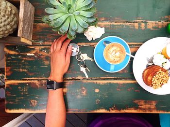 Cropped image of person by key and food on table