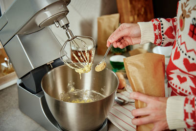 Woman cooking at home kitchen, use electric mixer to preparing dough
