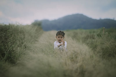 Portrait of kid sitting on grassy field