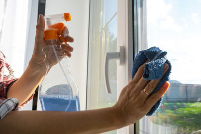 Midsection of woman holding bottle