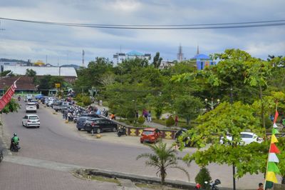 Cars on road in city against sky