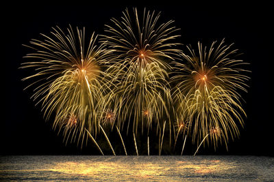 Colorful fireworks celebration from the sea with the midnight sky background.