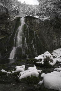Scenic view of waterfall against sky during winter
