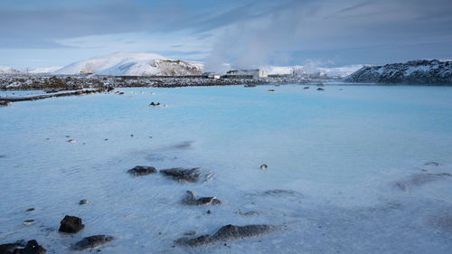 Scenic view of sea and snowcapped mountains against sky