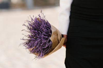 Purple bouquet in the hands of a woman close-up