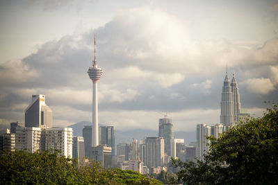 Skyscrapers in city against cloudy sky