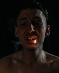 Portrait of young man against black background