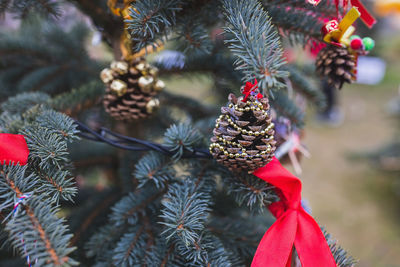 Natural pine cone decorated with gold string beads on christmas tree. diy decoration ideas