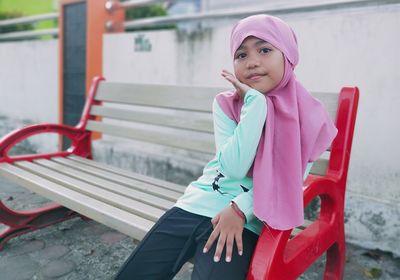 Portrait of girl sitting on bench