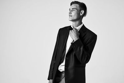 Young man looking away against white background