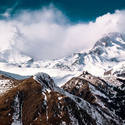 Scenic view of snowcapped mountains against cloudy sky