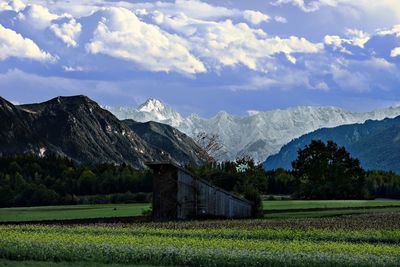 Scenic view of field and mountains against sky