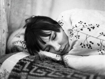 Close-up of woman lying on bed at home