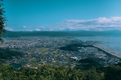 High angle view of townscape by sea against sky