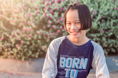 Portrait of smiling boy standing against blurred background