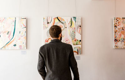 Rear view of man standing against wall