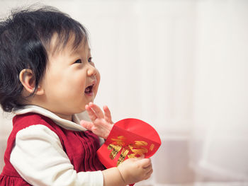 Close-up of cute girl holding red envelope