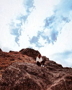People standing on rock against sky