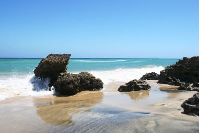 Scenic view of sea against clear blue sky