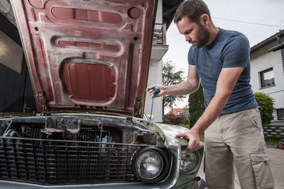 Man repairing car outdoors