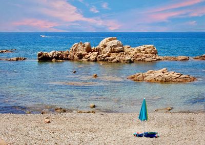 Scenic view of rocks on beach against sky