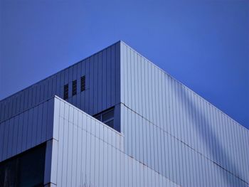 Low angle view of factory against clear blue sky