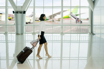 Businesswoman with luggage walking at airport