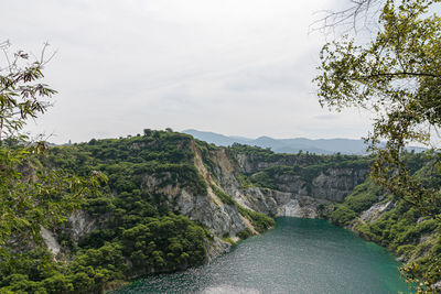 Scenic view of river amidst trees against sky