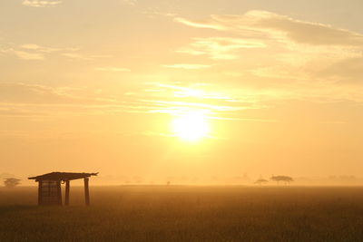 Scenic view of field against sky during sunset