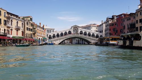 Arch bridge over canal against buildings in city