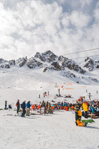 People on snowcapped mountain against sky