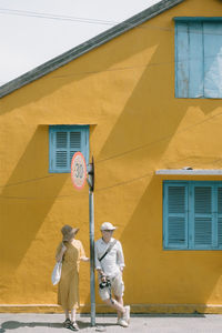 Full length of young man standing against building