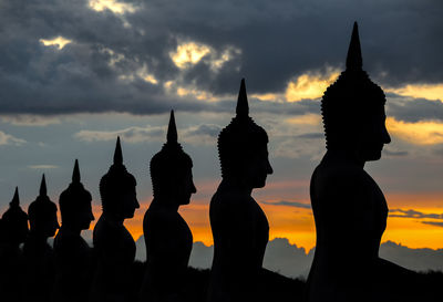 Silhouette of statues at sunset