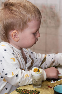 Portrait of boy with drink on table