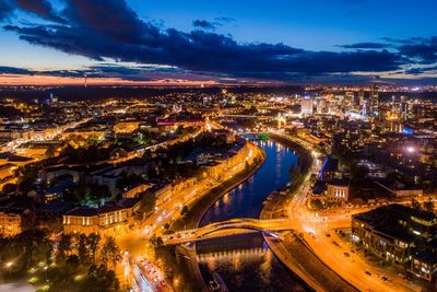 High angle view of illuminated city street and buildings at dusk