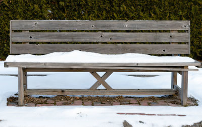 Empty bench in park during winter