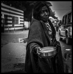 Portrait of man standing on street in city