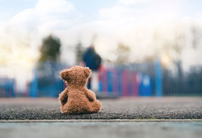 Close-up of stuffed toy on road against sky