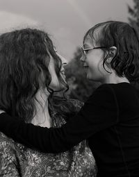 Close-up of mother with daughter against sky