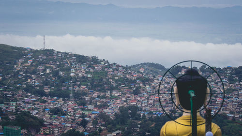 Woman looking at city buildings against sky